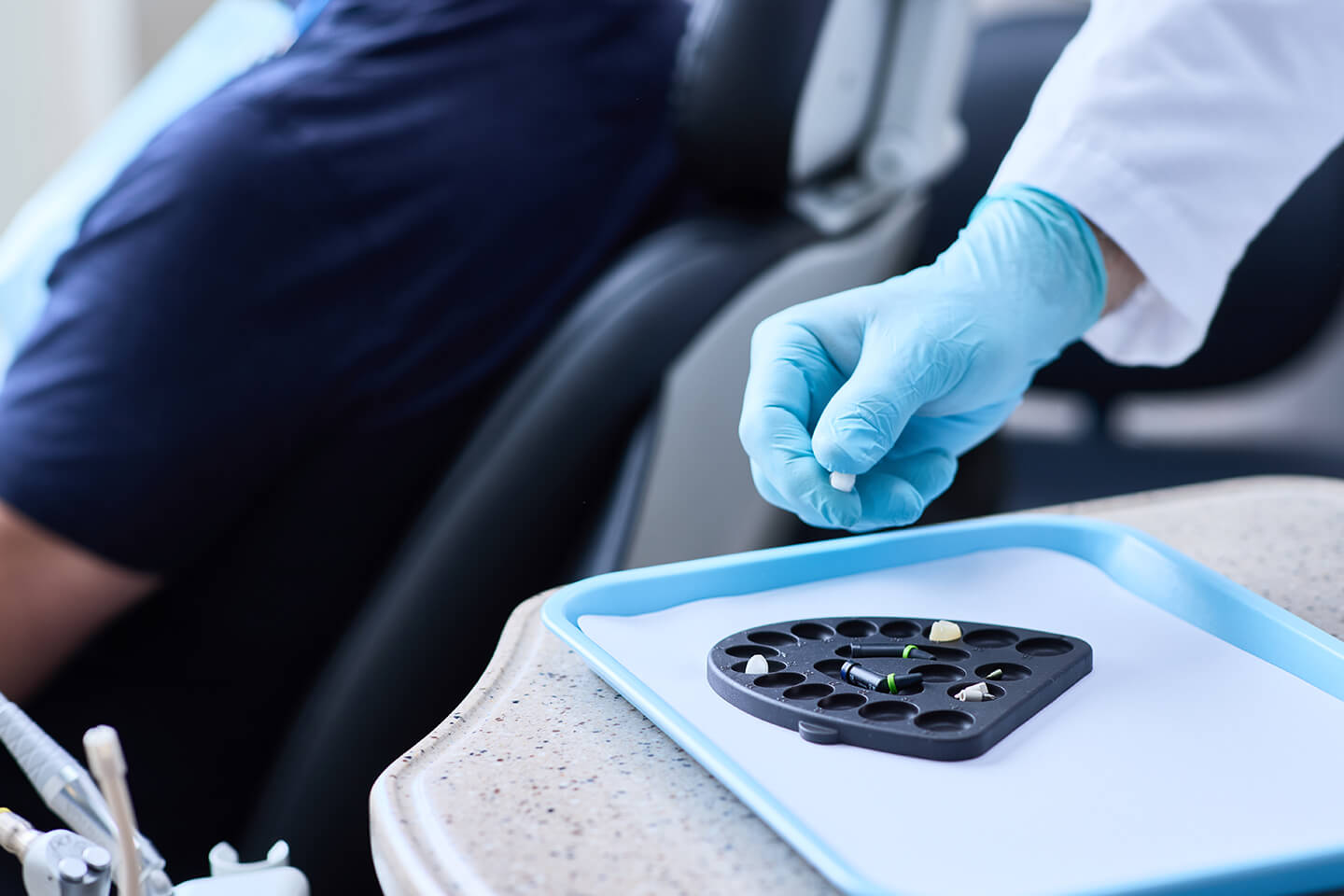 Gloved dentist using Prepster restorative workflow organizer on dental tray